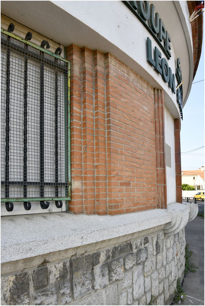 Façade sur rue. Angle des deux ailes. Détail du décor en béton des appuis de fenêtre.