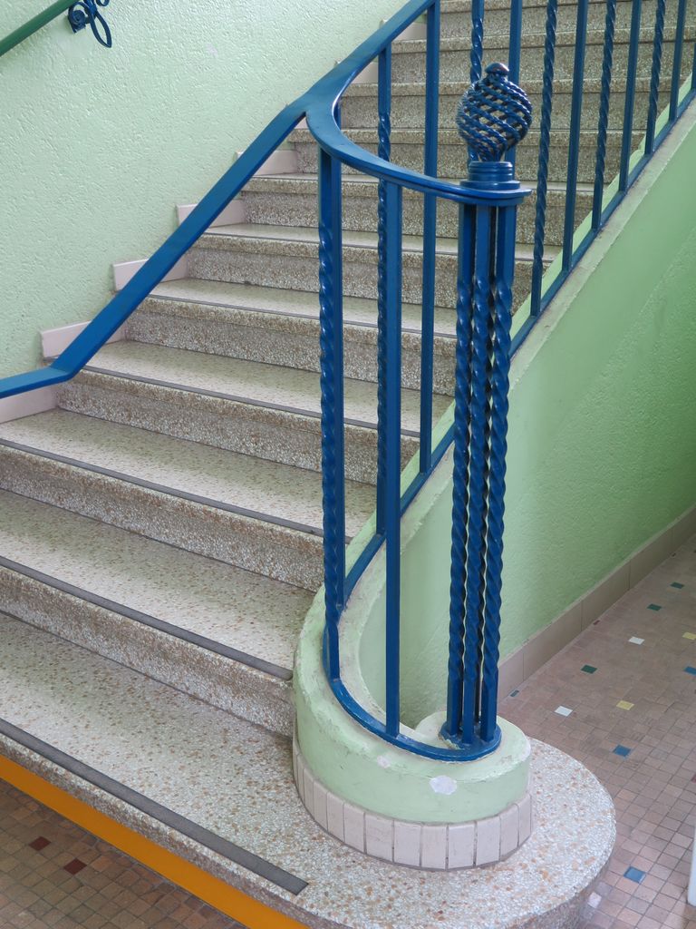 Grande cage d’escalier vitrée. Rampe en ferronnerie.