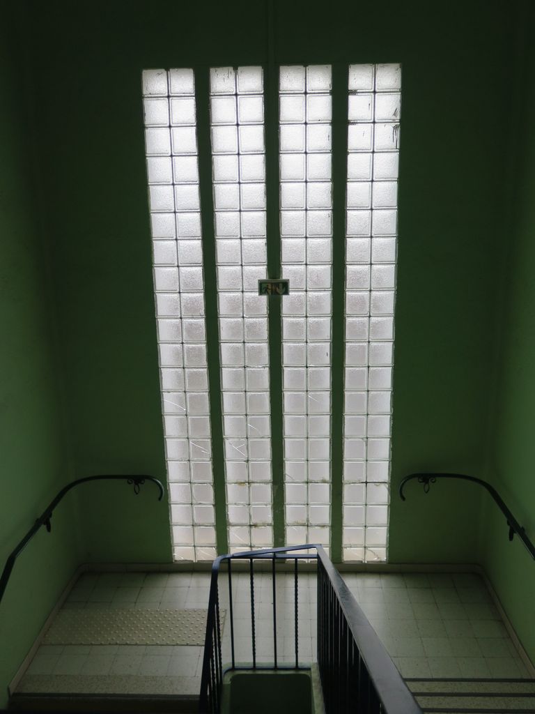 Grande cage d’escalier vitrée en pavés de verre.