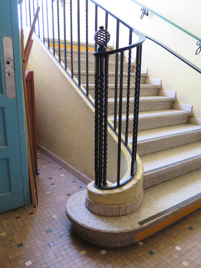 Grande cage d’escalier vitrée. Rampe en ferronnerie.