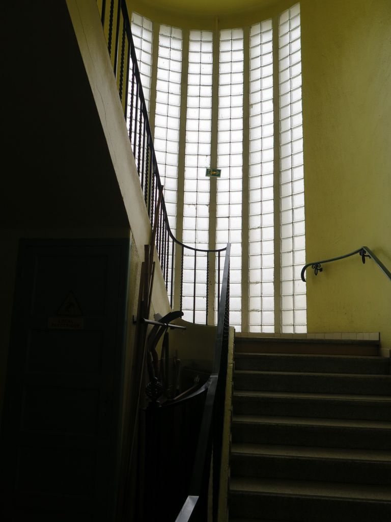 Grande cage d’escalier vitrée en pavés de verre.