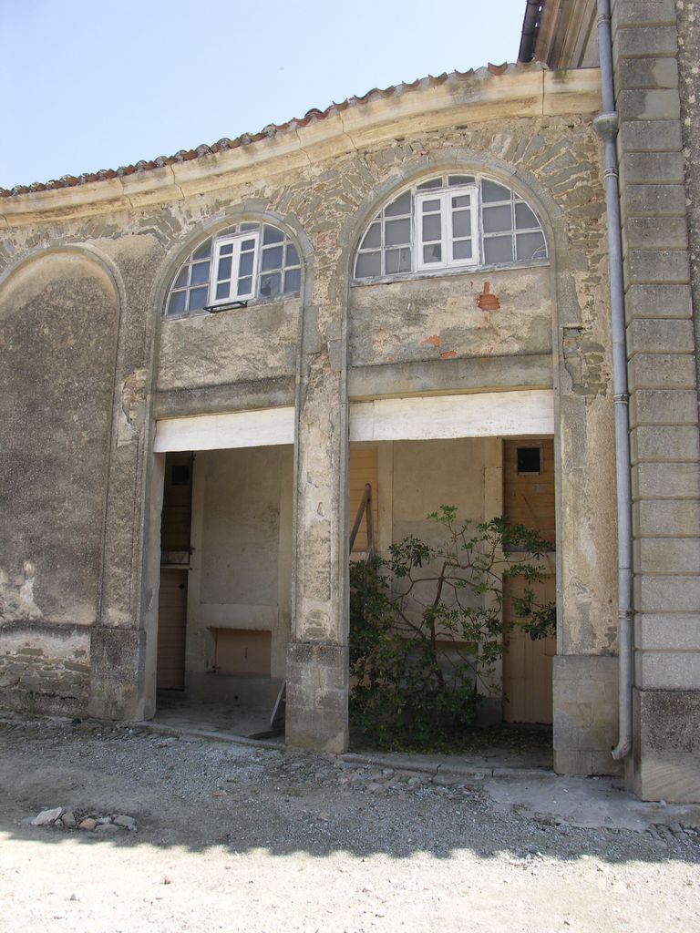 Communs. Cour semi-circulaire des communs. Passage entre pavillon d’habitation et écuries : porchères.