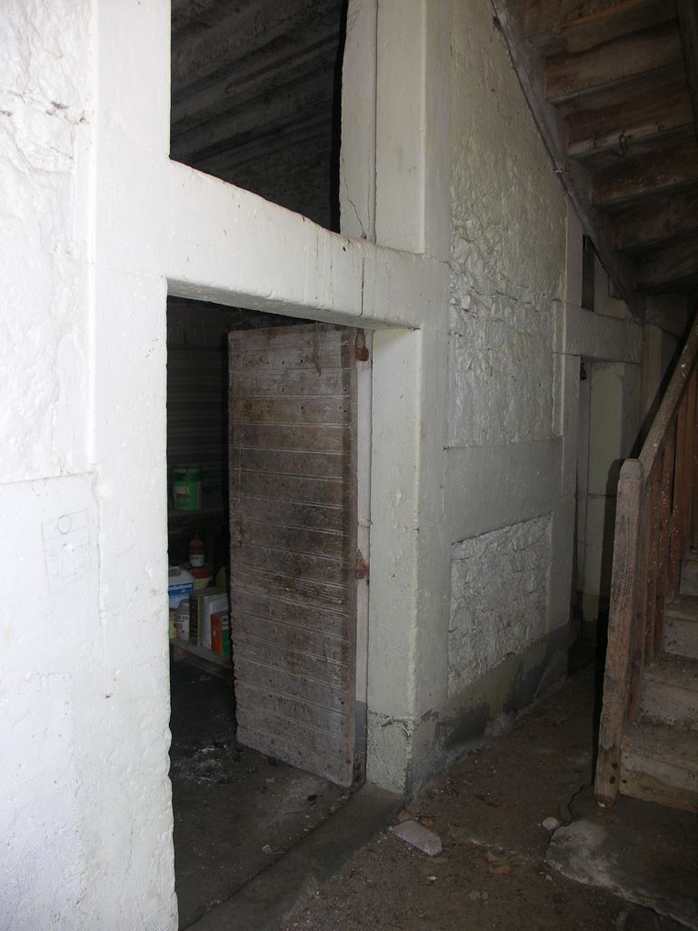 Communs. Cour semi-circulaire des communs. Pavillon du régisseur. Escalier en bois menant à l’étage du logement.