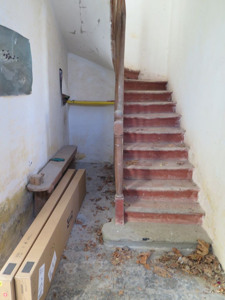 Communs. Cour semi-circulaire des communs. Pavillon du régisseur. Escalier en bois menant à l’étage du logement.