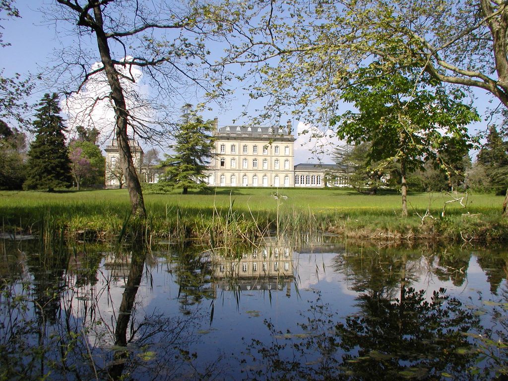 Parc. Le château se reflétant dans la pièce d’eau.