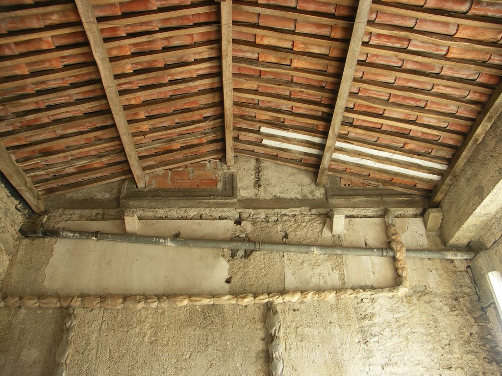 Orangerie ouest. Non aménagée. Les encadrements de fenêtres du mur du pavillon adossé sont coupés par la charpente de l’orangerie