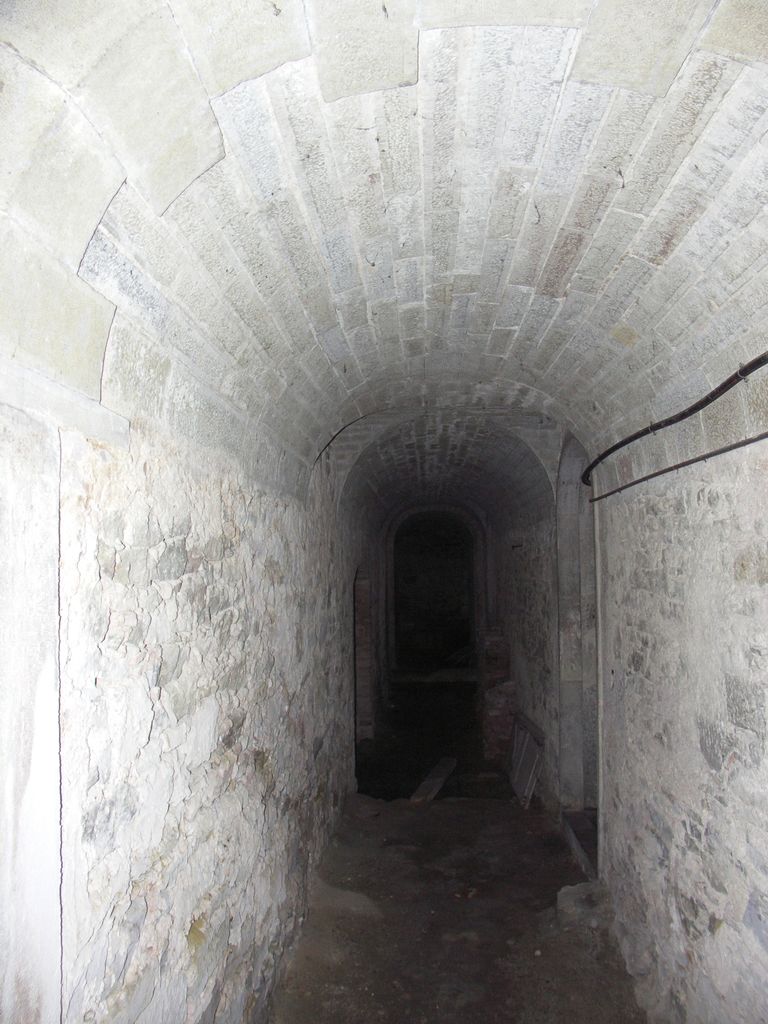 Château. Intérieur. Extrémité ouest. Cave citerne et à l’amenée d’eau de la source.