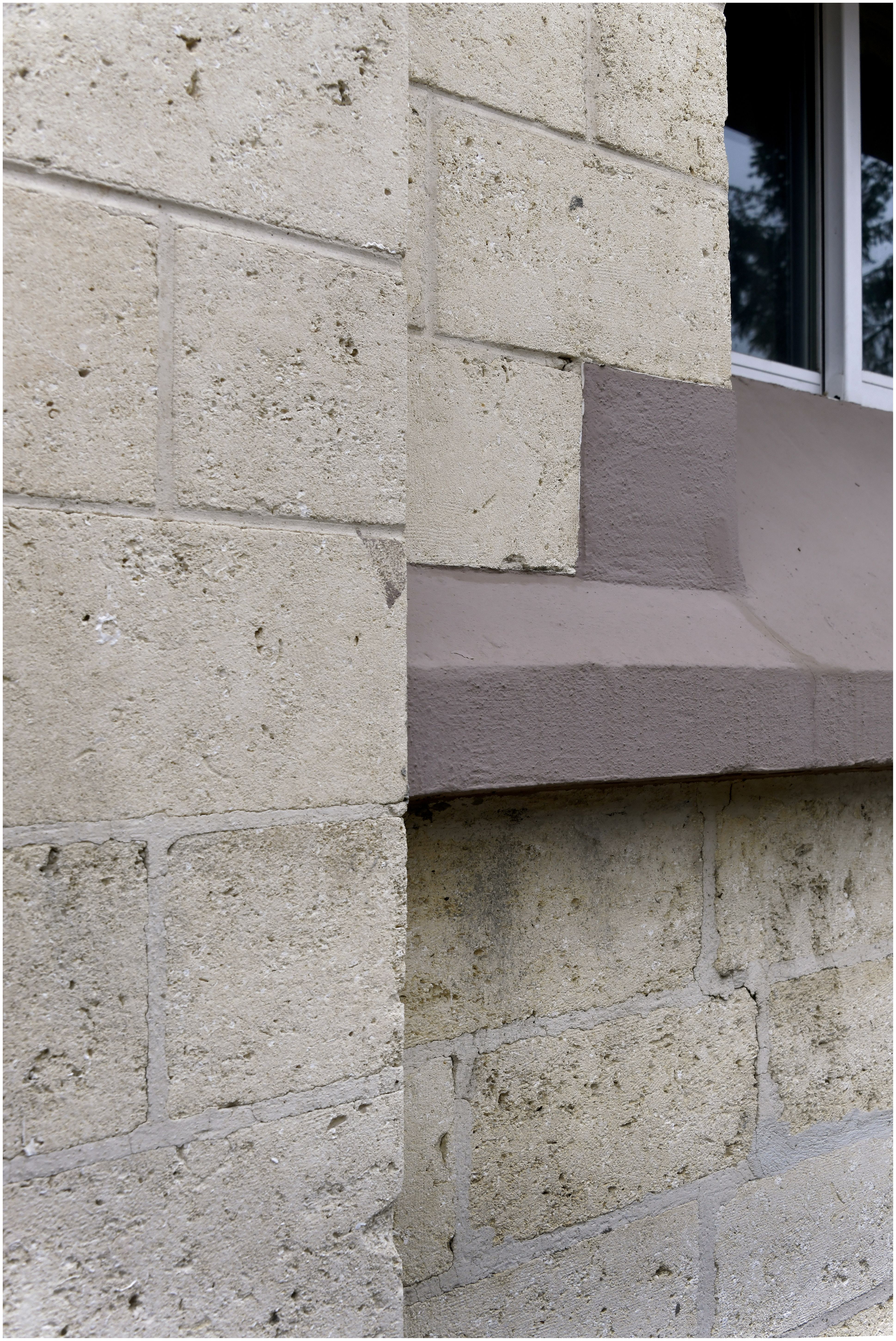 Façade sur l’avenue des sports. Détail de la mise en œuvre des murs en pierre et des appuis de fenêtres en béton