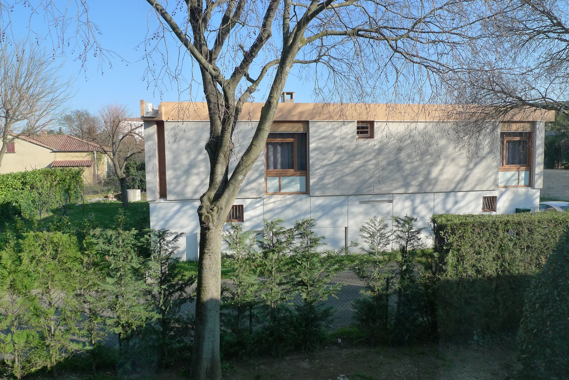 De l’étage, vue sur la façade latérale d’une autre villa de la placette.