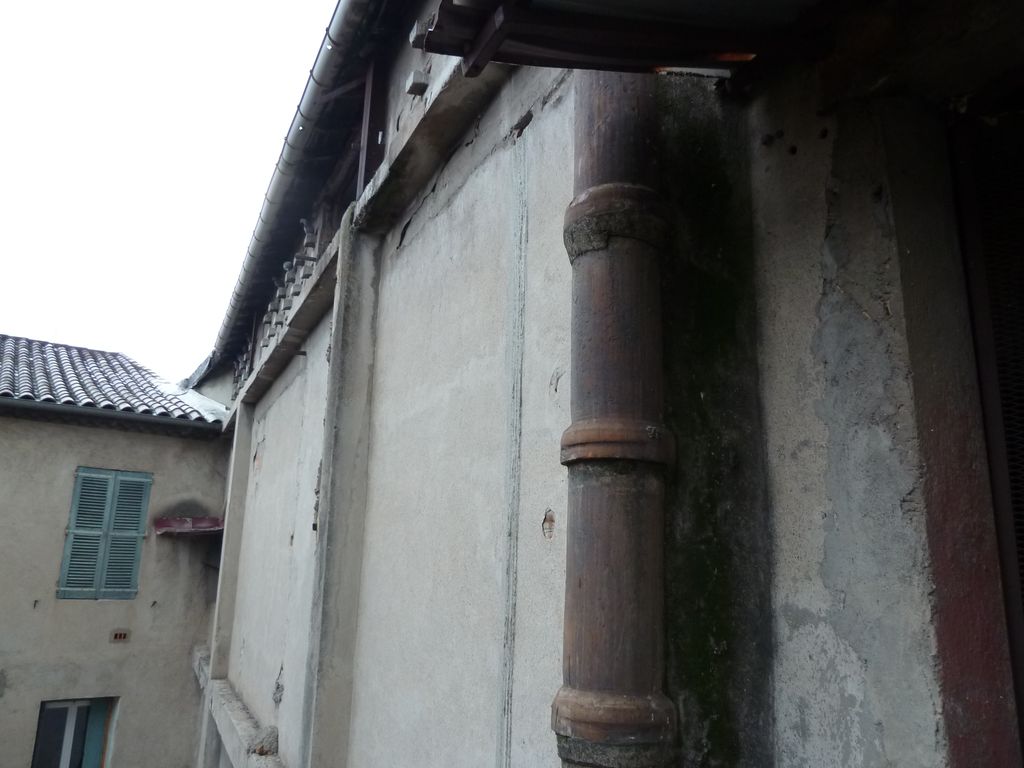 Façade arrière. En cœur d’îlot, résille poteaux poutre en béton armé et remplissage en brique creuse + enduit ciment motifs sous le toit