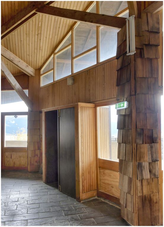 Vue de l’église haute, construite par Joseph Belmont en 1962 : intérieur, une des portes donnant sur la galerie extérieure