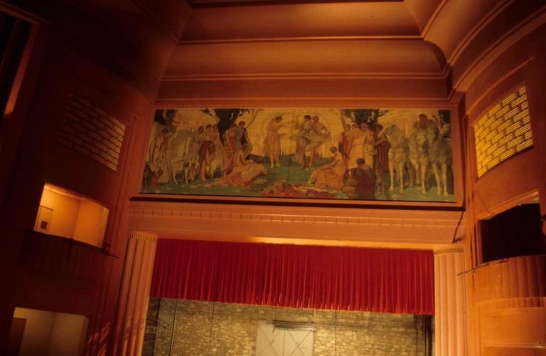 Salle de spectacle. Décor au dessus du rideau de scène.