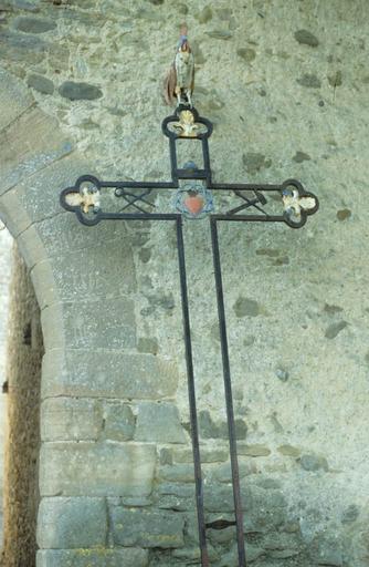 Croix en fer forgé à côté de la porte fortifiée des anciens remparts du Nord-Ouest.