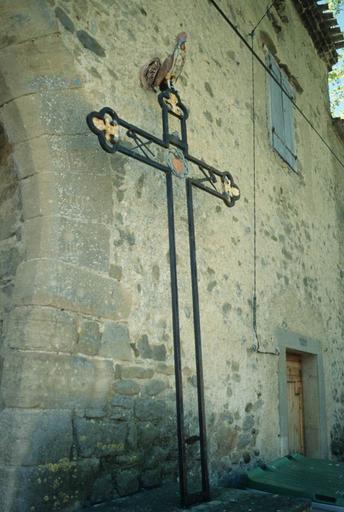 Croix en fer forgé à côté de la porte fortifiée des anciens remparts du Nord-Ouest. Détail du coq.