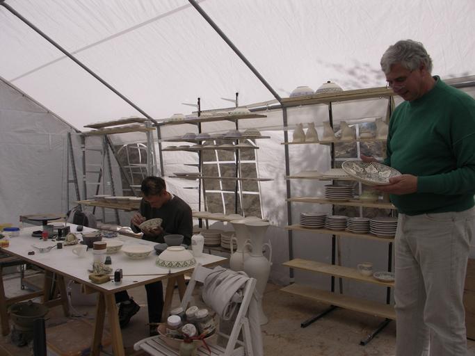 Atelier de potier installé provisoirement sous une tente.