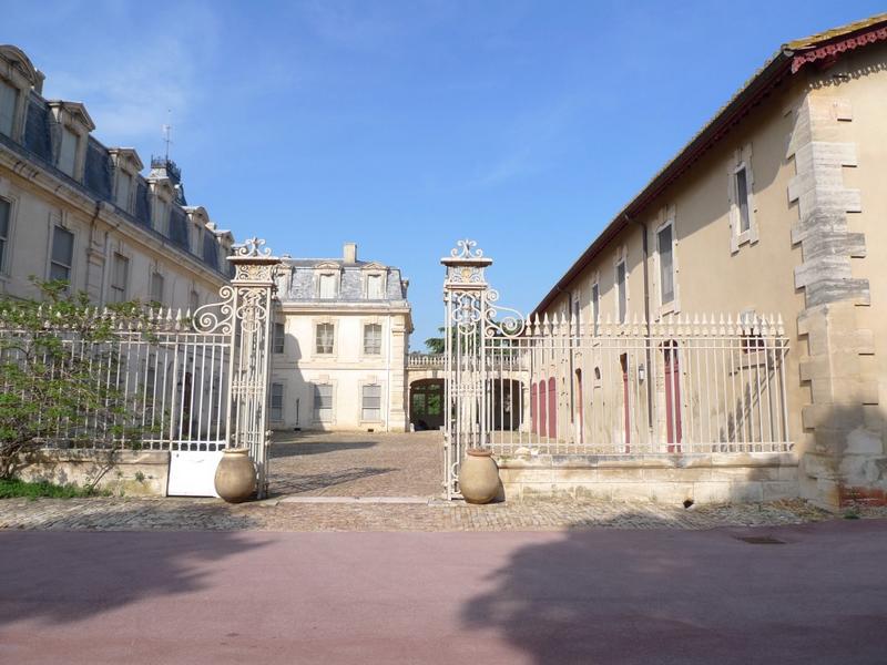 Entrée dans la cour du château et façade Sud des écuries.