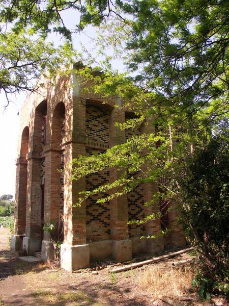 Bâtiment en briques vernissées bordant le chemin menant au champ de fouilles.