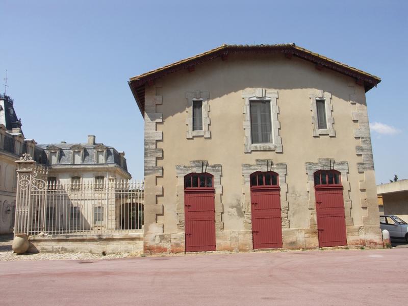 Façade Est de l'écurie et grille fermant la cour.