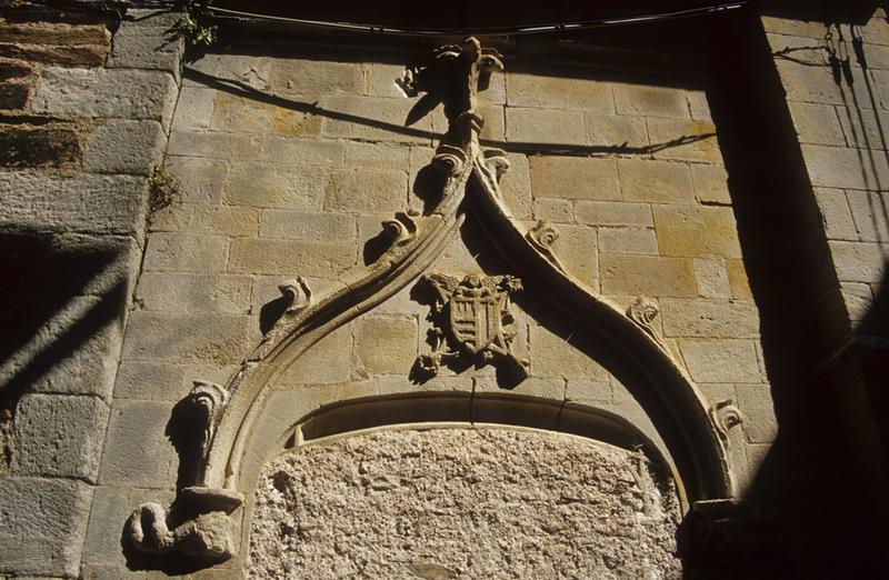 Fronton sculpté d'une porte murée.