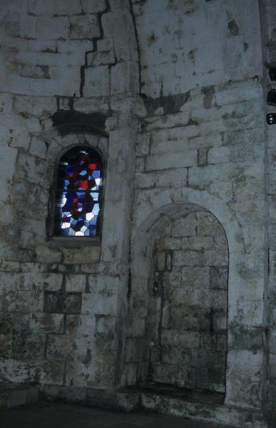 Intérieur ; partie du choeur avec une fenêtre et son vitrail et une niche.