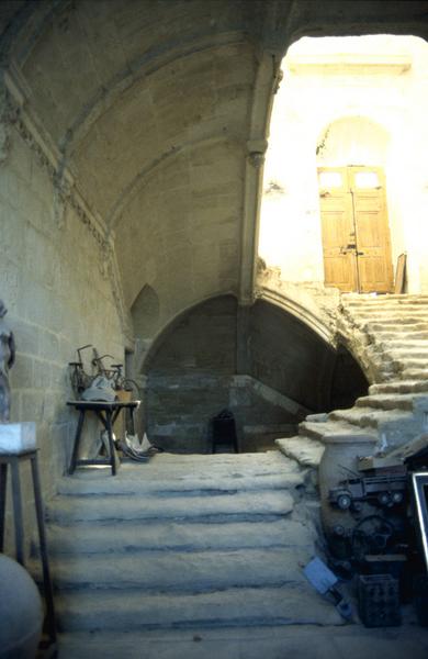 Intérieur : escalier, vue vers l'entrée sur la place avec une volée portée sur voûte en demi-berceau.