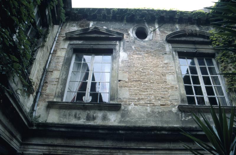 Cour intérieure : baies, murs en brique.