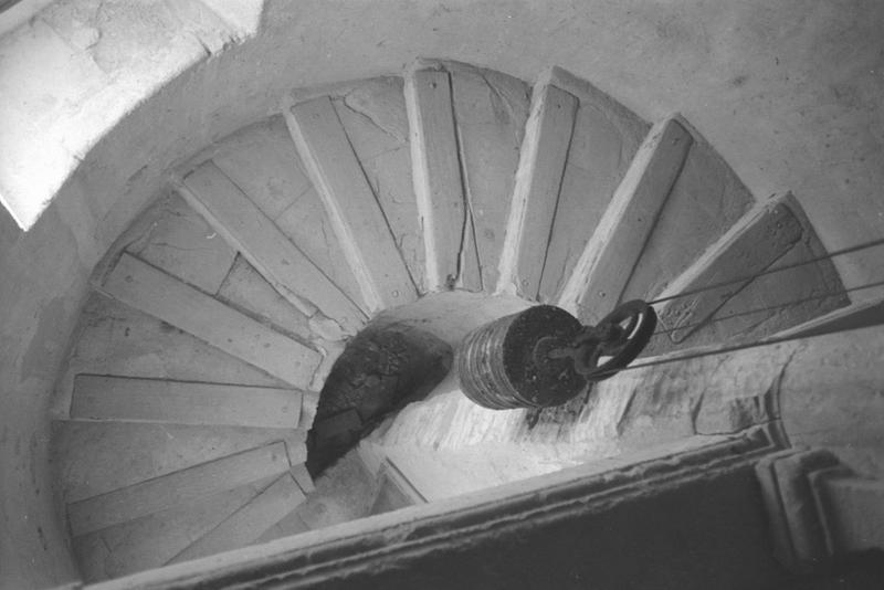 Vue intérieure : escalier et poids de l'horloge.