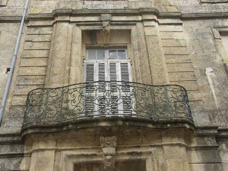 Façade latérale : balcon au-dessus de l'entrée sur rue.