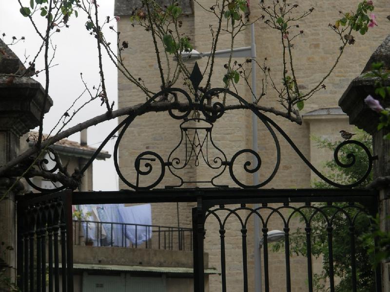 Portail sur la place de l'église : ferronnerie avec les initiales AM.