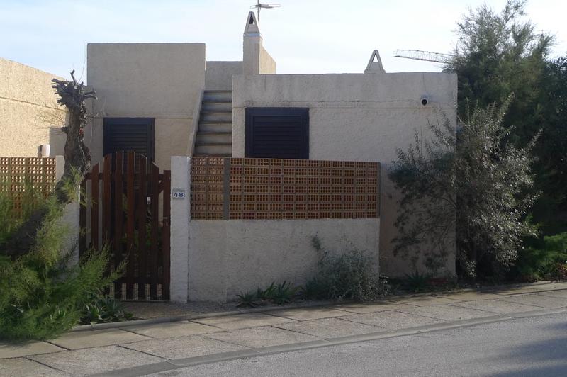 Village grec construit par Candilis : villa mitoyenne avec muret, claustras et accès au toit par escalier droit.