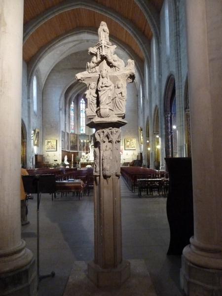 Croix en pierre. Revers : la Vierge à l'Enfant sous un dais soutenu par deux anges entre sainte Catherine et sainte Barbe. Au sommet : deux statuettes de saints.