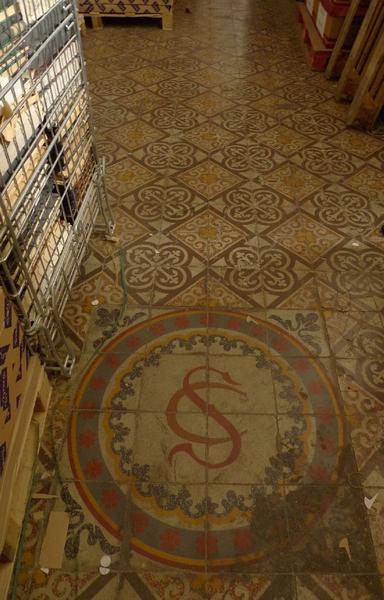 Intérieur, rez-de-chaussée : aile sud, sol de l'ancienne chapelle avec monogramme de Saint Claude pour l'évêque Claude de Chaffoy.