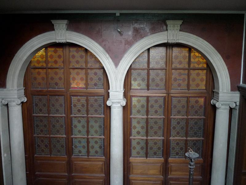 Intérieur : cage d'escalier, double arcade (maintenant vitrées) ouvrant sur le vestibule.