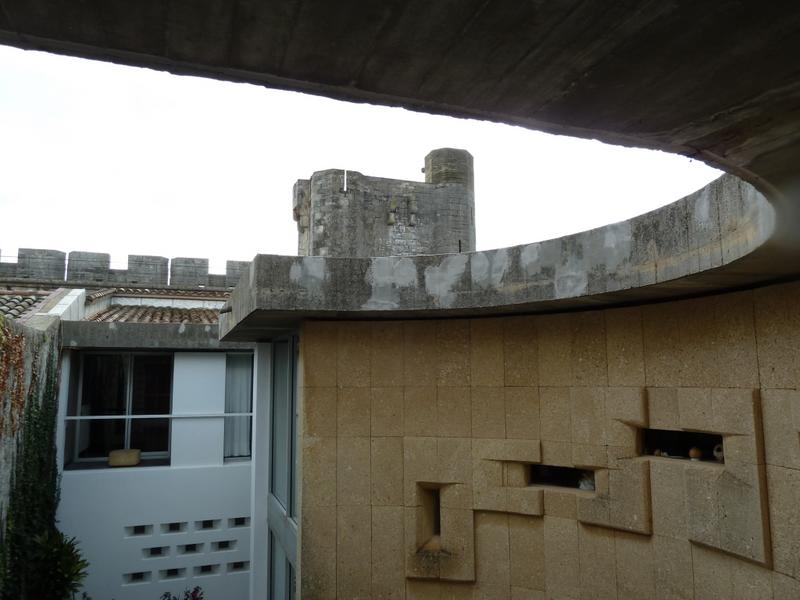 Courbe sur le patio et remparts en arrière plan.