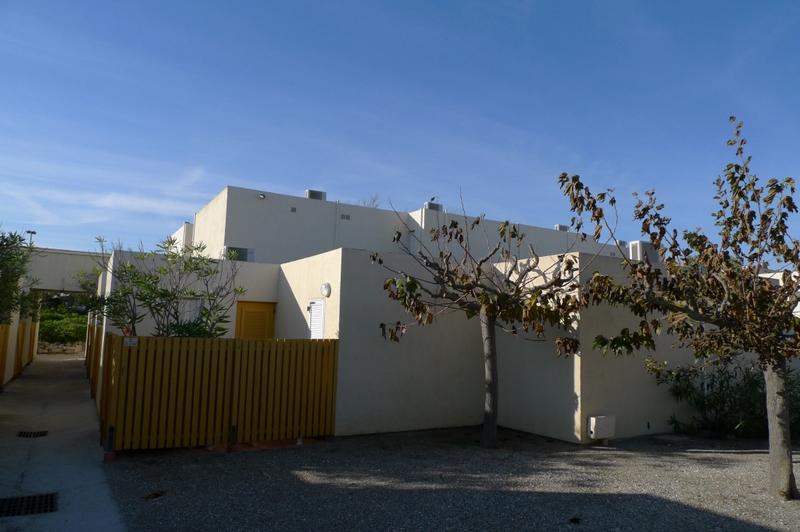 Logements cubiques groupés, avec patio privatif fermé par clôture en bois.