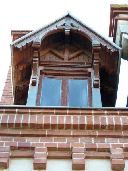 Façade sud : lucarne, briques et bois.