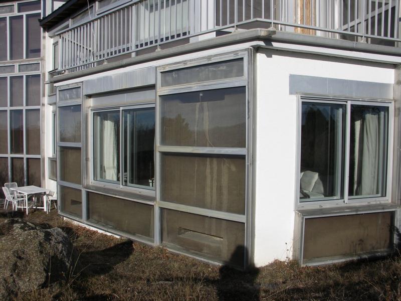 Partie de M. Ducarroir, RDC : mur de béton peint couleur terre avec ouvertures basse et haute pour la circulation d'air entre le mur Trombe et l'intérieur de l'habitation.