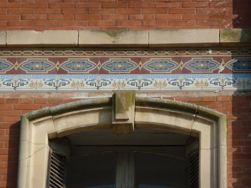 Façade ouest. Frise en céramique soulignant les niveaux.