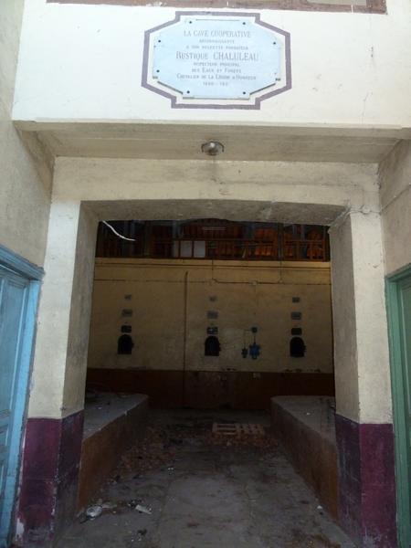 Cave de 1914. Entrée des bureaux. Plaque en l'honneur du fondateur Rustique Chaluleau.