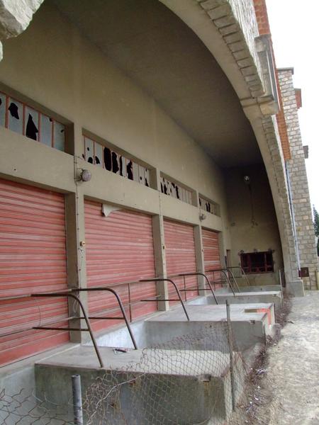 Détail des quais abrités sous l'arc surbaissé qui laisse voir la structure en béton armé derrière le plaquis de pierre apparentes.