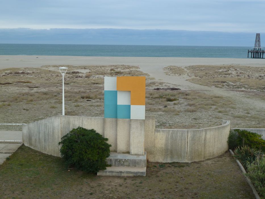 Exèdre signalant le village de vacances, avec l'enseigne dessinée par Anja Blomstedt, côté plage.