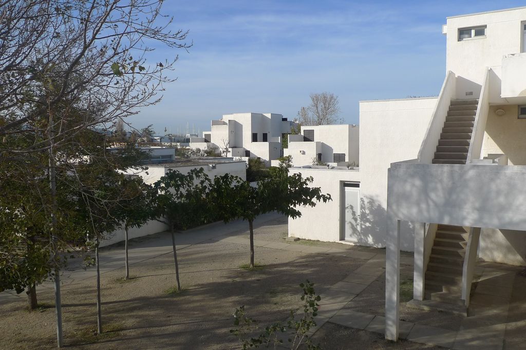 Logement collectif au 1er plan et blocs de bungalows en arrière : la hauteur des collectifs protégeant les bungalows des assauts du vent.