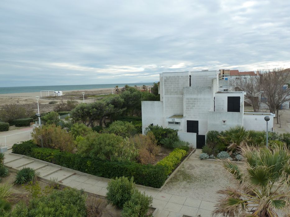 Collectifs en première ligne sur la plage, enserrés dans un aménagement paysager rustique, résistant au sel et au vent, caractéristique des plantations de la Mission Racine.