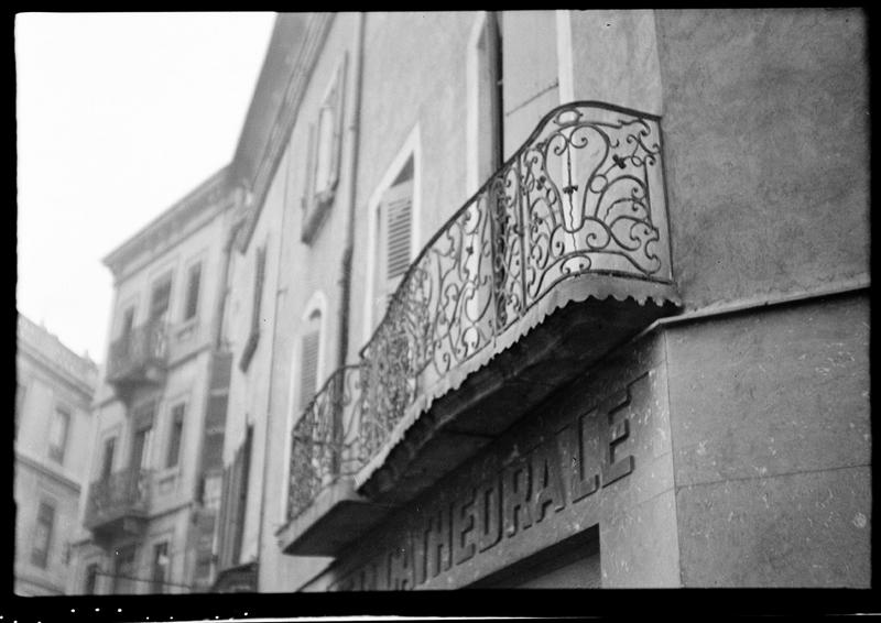 Façade sur la place ; deux balcons en fer forgé du premier étage.