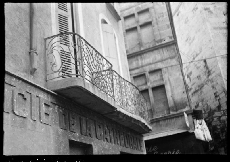 Façade sur la place ; deux balcons en fer forgé du premier étage.