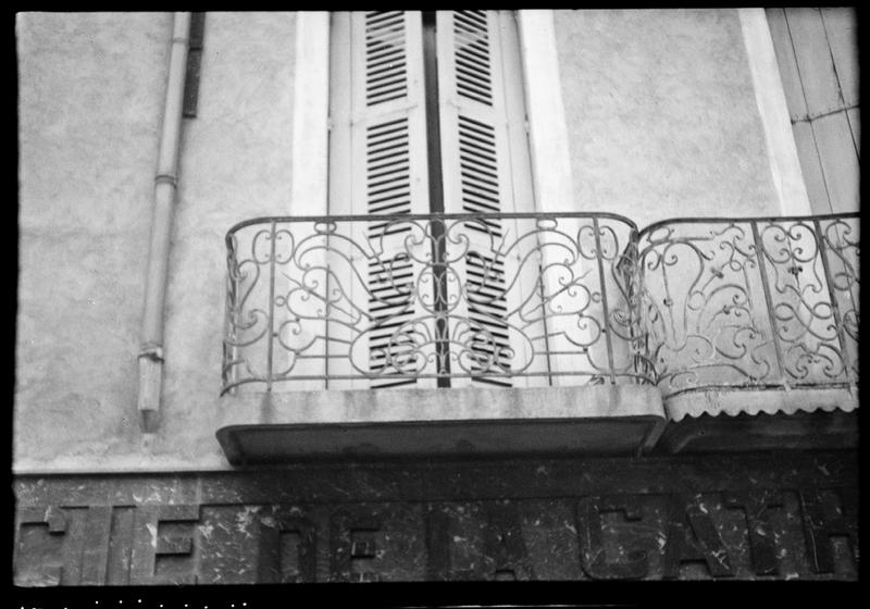 Façade sur la place ; deux balcons en fer forgé du premier étage.