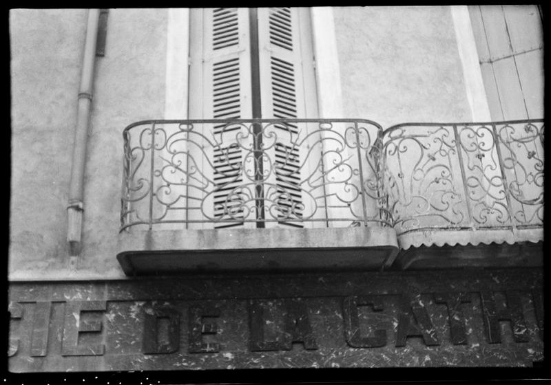 Façade sur la place ; deux balcons en fer forgé du premier étage.