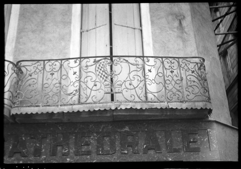 Façade sur la place ; deux balcons en fer forgé du premier étage.