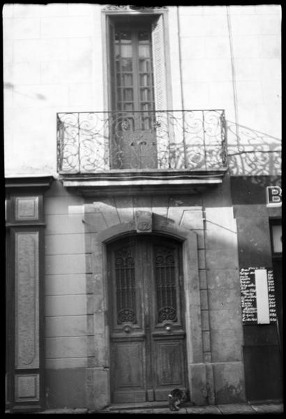 Façade sur rue ; portail et balcon en fer forgé.