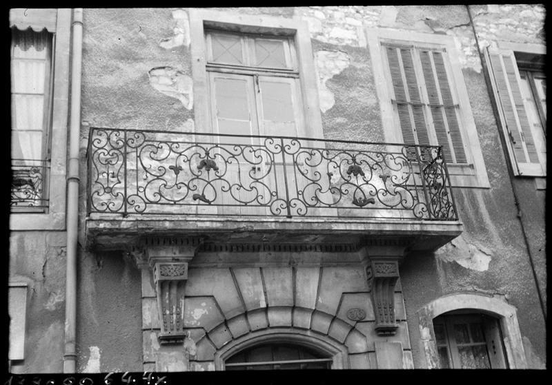 Façade sur rue ; arc du portail et balcon en fer forgé le surmontant.